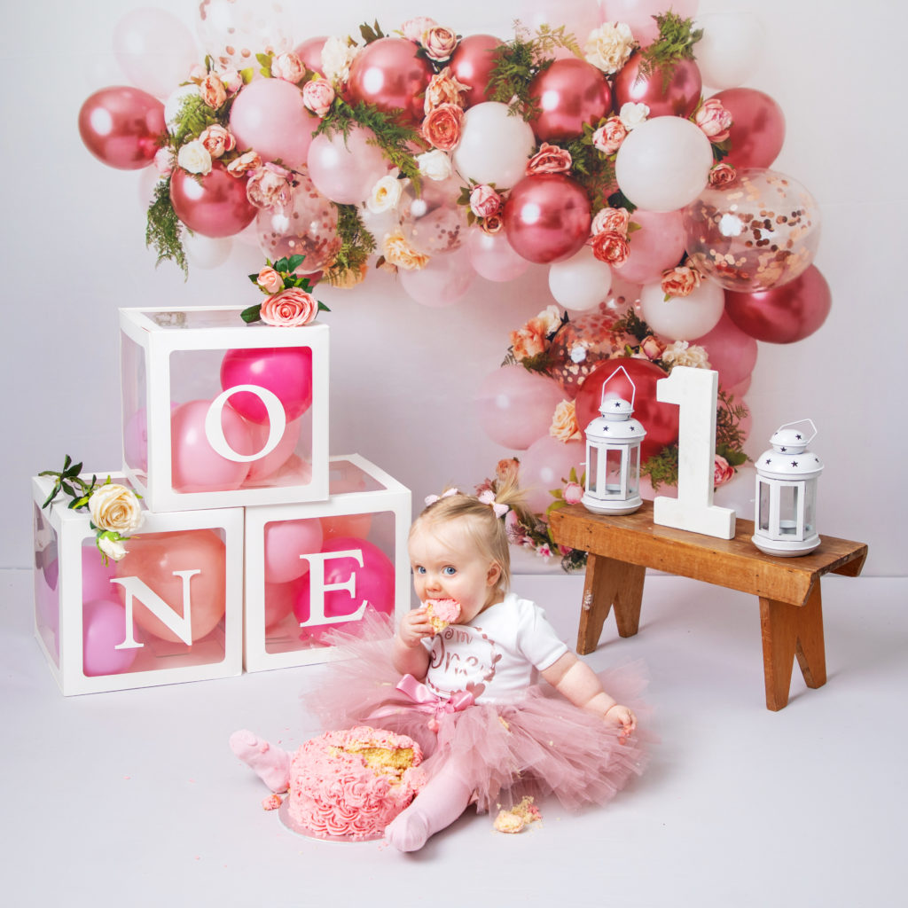 1st pink Birthday Cake Smash Photography taken by a profession photographer in her studio in Whitchurch Hampshire